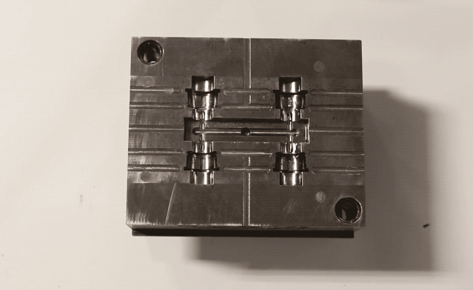 muestra mano pasando un pañuelo por un molde para inyección de plástico